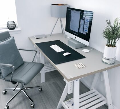 gray leather office rolling armchair beside white wooden computer desk